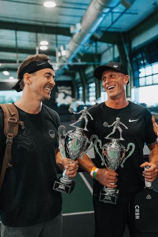 Two men holding trophies