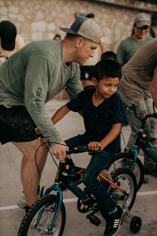 Max helping a kid ride a bike